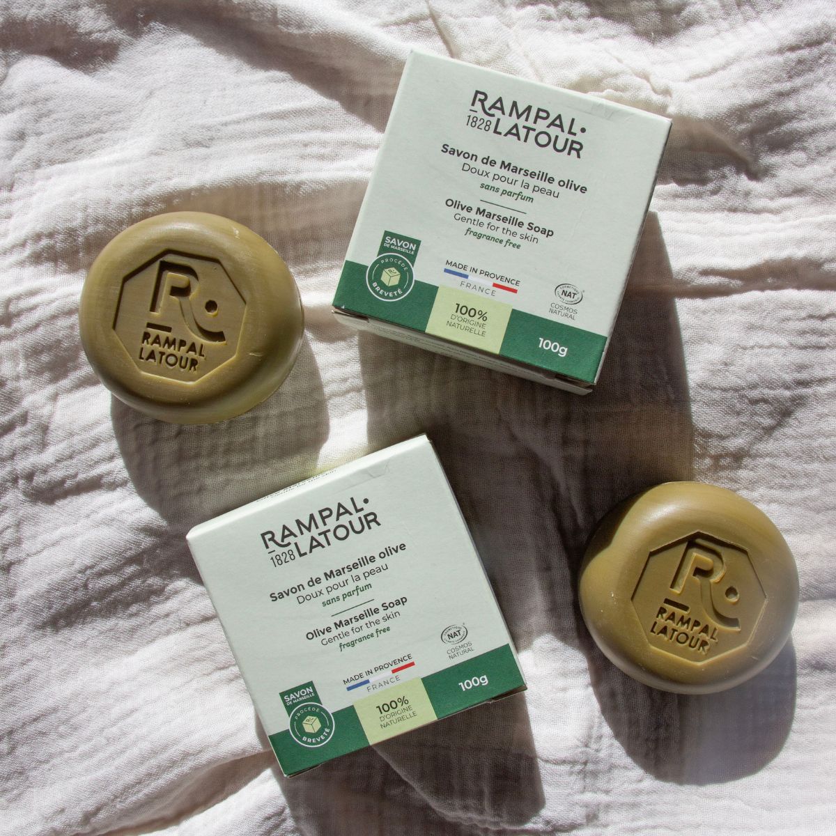 Savons de Marseille à l'huile d'olive Rampal Latour, doux pour la peau, posés sur un tissu en lin